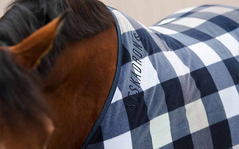 Nahaufnahme einer karierten Abschwitzdecke auf dem Pferd